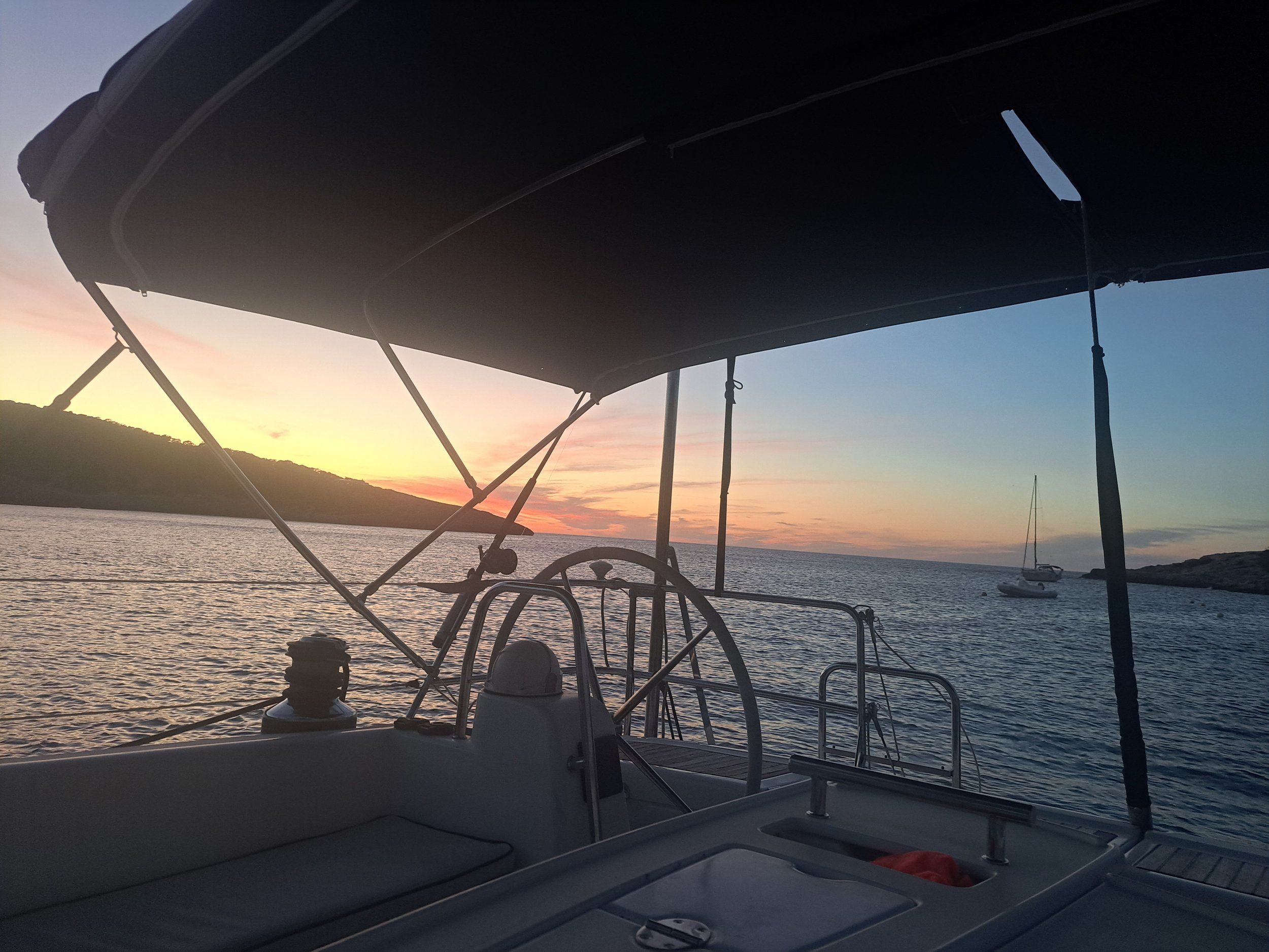 Al timón del velero al anochecer