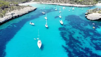 Bahía turquesa llena de veleros, vista aérea